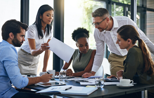 team members looking at paperwork over a desk